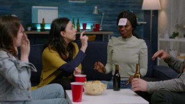 Yapışkan notlar kullanarak masa oyunu oynarken gülen çok ırklı arkadaşlar