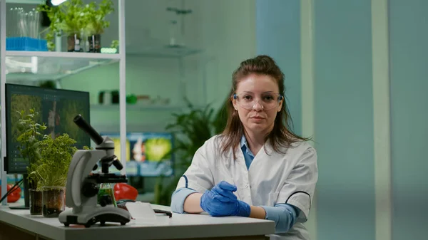 Pov de la mujer botánica en la bata blanca escuchar equipo de químicos durante videocall en línea —  Fotos de Stock