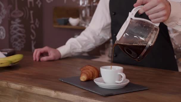 Mozi egy férfi barista lassan töltse meg a csésze kávét — Stock videók