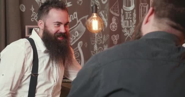 Hipster elegant cu barbă neagră lungă sorbind whisky la un bar cu prietenul său — Videoclip de stoc