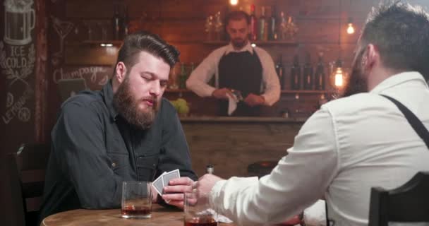 Due uomini finiscono un gioco di carte e sorridono stringono la mano — Video Stock