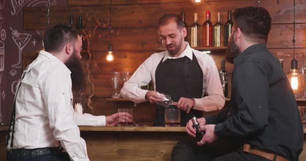 Uomini che raccontano storie in un bancone di un bar godendo di una conversazione amichevole — Video Stock