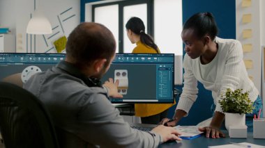 Çeşitli mühendisler mekanik parçaların tasarımında bilgisayar üzerinde çalışıyorlar.