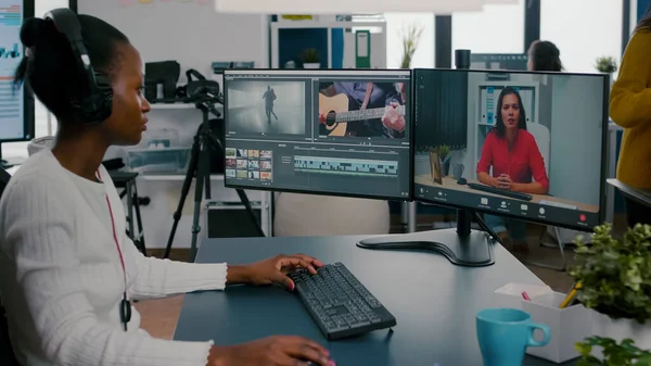 African woman editor with headset talking during online conference