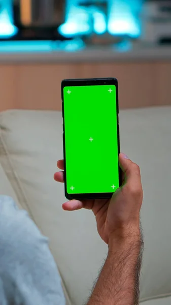 Uomo rilassato guardando smartphone con display a chiave cromatica dello schermo verde — Foto Stock