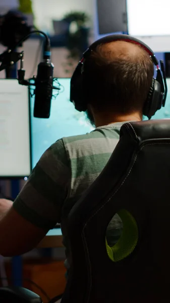Πλάτη βολή του streamer άνθρωπος παίζει σε ισχυρό υπολογιστή shooter video game — Φωτογραφία Αρχείου