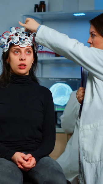 Médecin chercheur ajustant casque EEG analysant l'évolution des patients — Photo