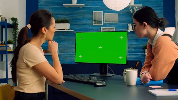 Twee collega 's werken samen op de computer met mock up groen scherm chroma key display — Stockfoto
