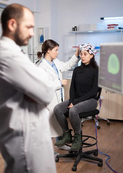 Neurociência cientista ajustando fone de ouvido com sensores em paciente mulher — Fotografia de Stock