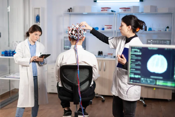 Vue arrière d'un patient homme portant un casque performant à balayage d'ondes cérébrales — Photo