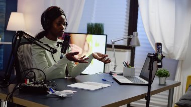 Kulaklık takan Afrikalı etkili yeni podcast ses kaydını kontrol ediyor