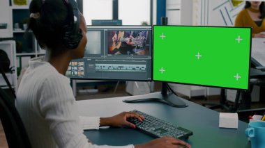 Kulaklıklı film montajı yapan Afrikalı kadın kameraman.