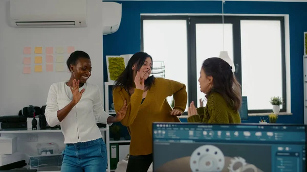 Lelkes, változatos mérnökök táncoló nők a céges irodában — Stock Fotó