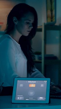 Modern evde çalışan uzak bir kadın tablete sesli komut veriyor