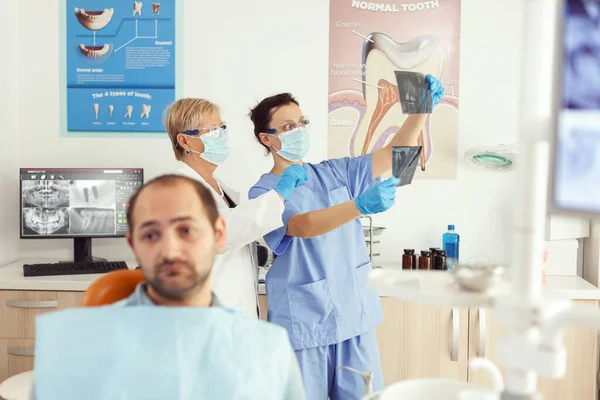 Пациент, сидящий на стоматологическом стуле, ждет врача-стоматолога — стоковое фото