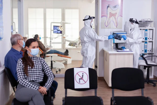 Kıyafet giymiş stomatoloji dişçisi hastanın röntgenini çekiyor. — Stok fotoğraf