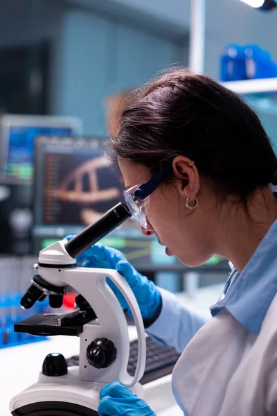 Scientist examining researching analyzing virus loking through microscope — Stock Photo, Image