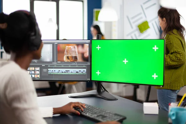 Editor de vídeo desenvolvendo nova montagem de filme projeto olhando para a tela verde — Fotografia de Stock