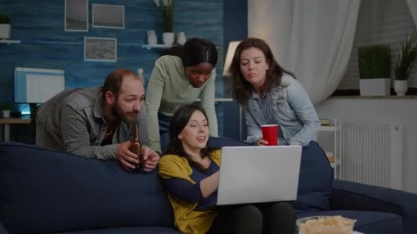 Multi-étnicos amigos viendo interesante película de comedia en el ordenador portátil — Vídeos de Stock