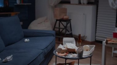 Boş dağınık oturma odasında, üzerinde yemek artıkları olan masayı kapat.