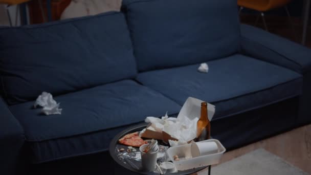 Закрыть грязный стол с остатками еды в пустой неорганизованной гостиной — стоковое видео
