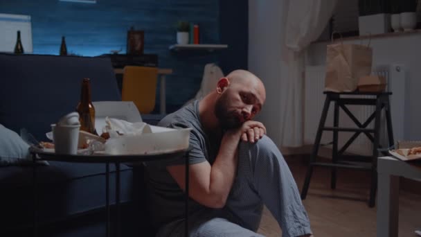 Depressiv man som sitter på golvet och tittar på kameran med dissapointed uttryck — Stockvideo