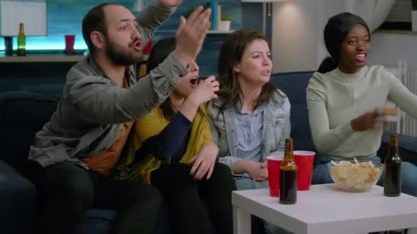 Группа смешанных людей смотрит спорт дома по телевизору — стоковое видео