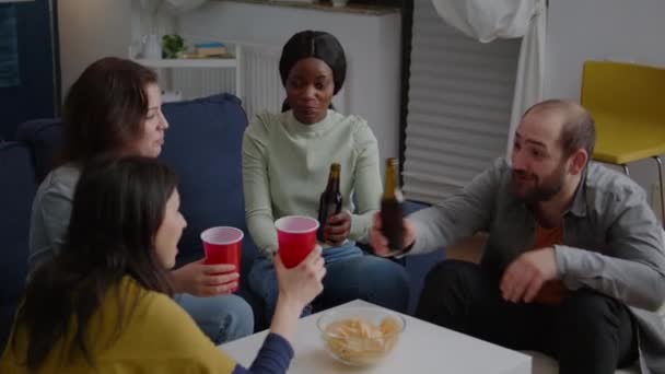 Мультикультурные друзья болеют за бутылки пива, проводя время вместе — стоковое видео