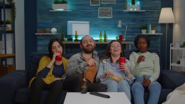 Amigos multiétnicos riendo mientras ven películas de comedia disfrutando del tiempo que pasan juntos — Vídeo de stock