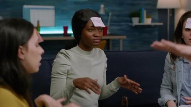 Alnında yapışkan notlar olan heyecanlı çoklu etnik arkadaşlar tahmin et kim oynuyor.