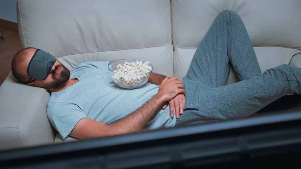 Caucasiano macho adormecer enquanto assiste filme show sentado no sofá — Fotografia de Stock