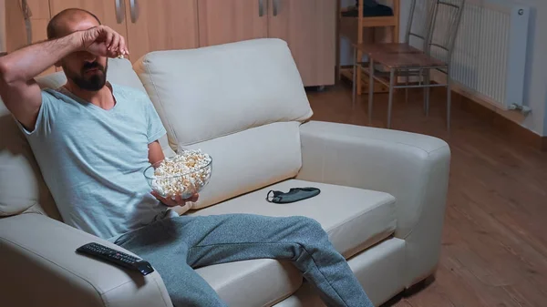 Homem concentrado refrigerando no sofá na frente da televisão assistindo série de filmes — Fotografia de Stock