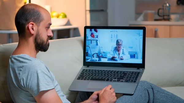 Homem caucasiano conversando com médico durante consulta on-line de telemedicina — Fotografia de Stock