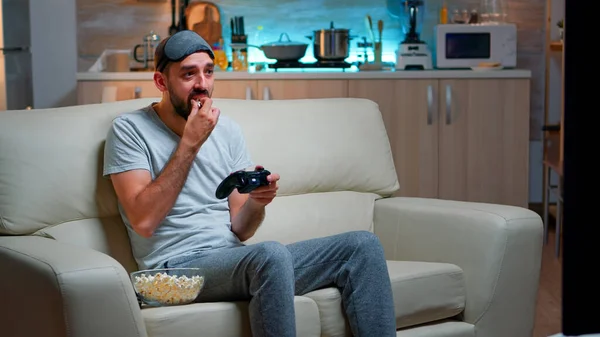 Upset pro gamer sitting on couch and playing soccer videogames — Stock Photo, Image