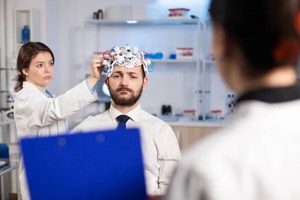 Neuroscience doctor showing on clipboard treatment against brain disease — Stock Photo, Image