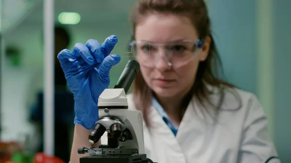 Closeup of scientist woman looking at test sample of lea — Stock Photo, Image