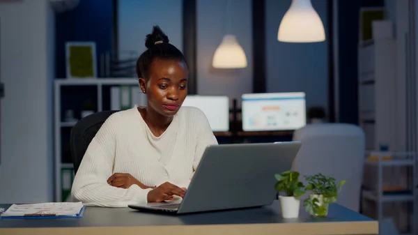 Gerente africano estressado mulher trabalhando com gráficos financeiros horas extras — Fotografia de Stock