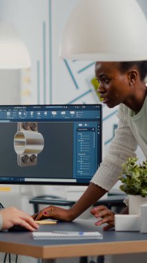 Endüstri mühendisi ve Afrikalı proje yöneticisi birlikte çalışıyorlar.