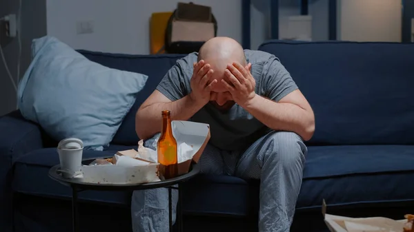 Депресія в депресії турбувала безнадійного чоловіка зі сльозами, що сидять на дивані — стокове фото
