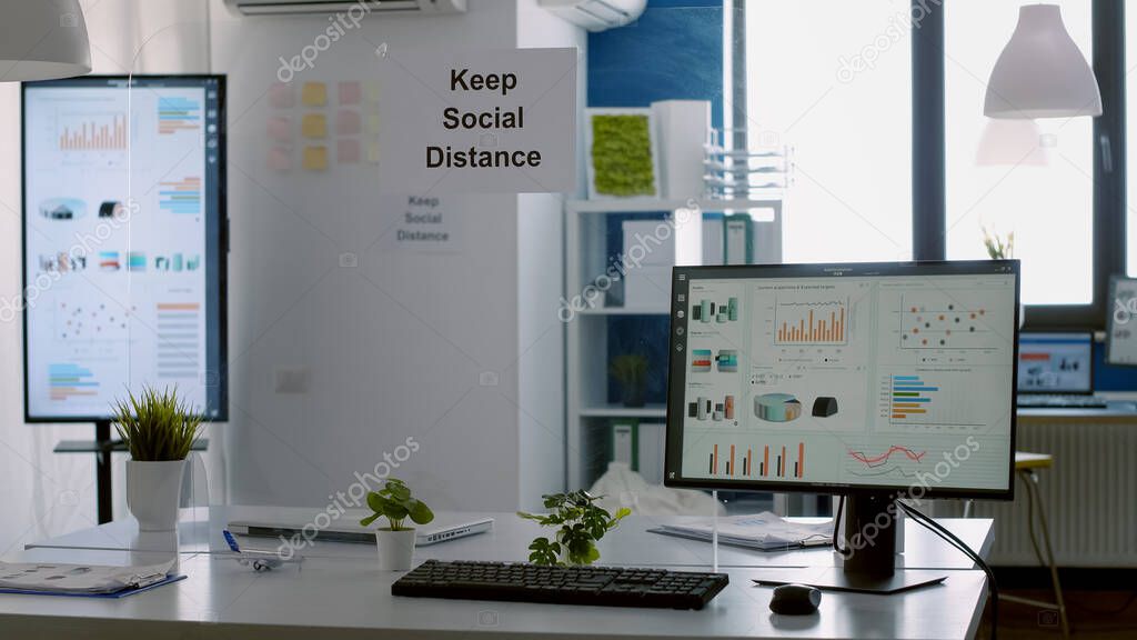 Modern empty office with plastic separators and keep social distance poster