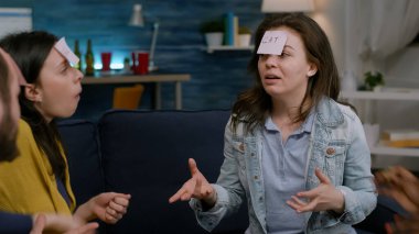 Çok ırklı arkadaşlar gece geç saatlere kadar koltukta oturup tahmin et kim oynuyor?