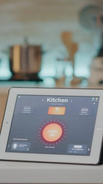 Kablosuz ışıklandırma otomasyon yazılımı olan tablete bakan adam