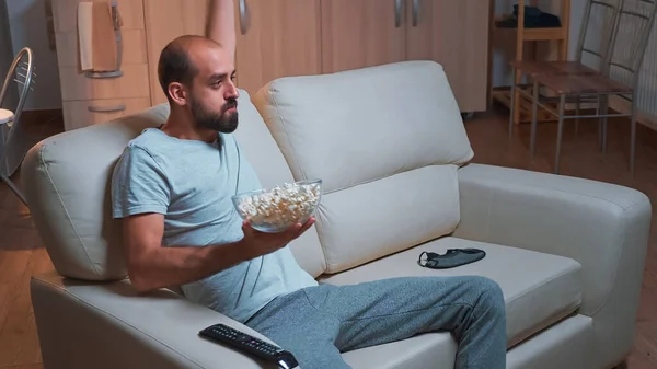 Homem concentrado assistindo filme de entretenimento enquanto faz expressão facial — Fotografia de Stock