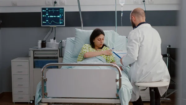Femme caucasienne avec tube d'oxygène nasal assis dans le lit dans la salle d'hôpital — Photo