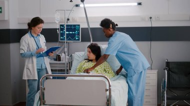 Tıbbi pratisyen doktor hasta kadını kontrol ediyor. Hastalık belirtilerini izliyor.