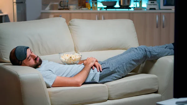 Мужчина закрывает глаза и засыпает на диване в гостиной — стоковое фото