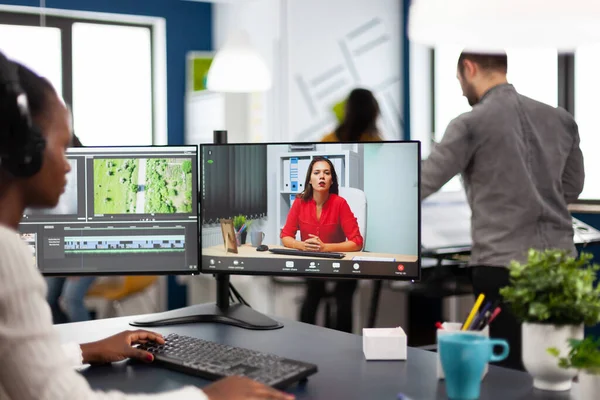 Afrikaanse vrouw editor met headset praten tijdens online conferentie — Stockfoto