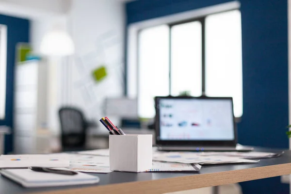 Ordinateur portable avec les tableaux financiers de l'entreprise sur bureau — Photo