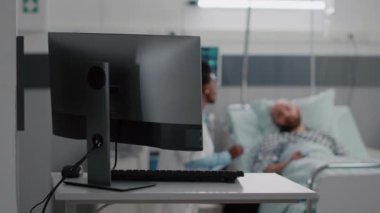 Afro-Amerikalı pratisyen doktor hasta adamla tedavi hakkında konuşuyor.
