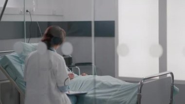 Tıbbi üniformalı uzman doktor hasta adamı kontrol ediyor. Hastalık uzmanlığı yazıyor.